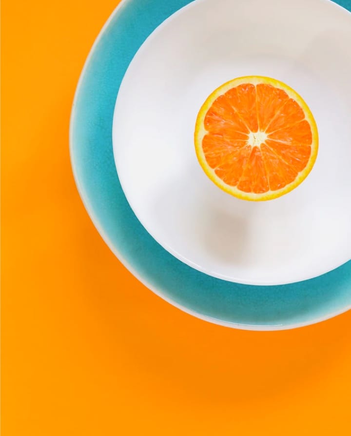 orange slice on plate with bright orange background