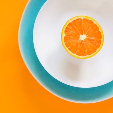 orange slice on plate with bright orange background